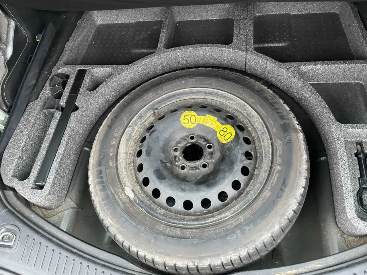 Koło zapasowe w bagażniku Forda S-Max, z narzędziami.